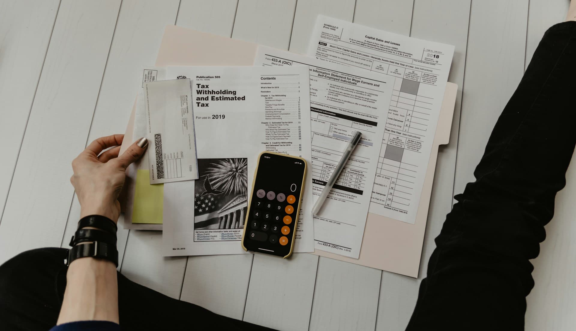 Calculator and money on a table with travel brochures