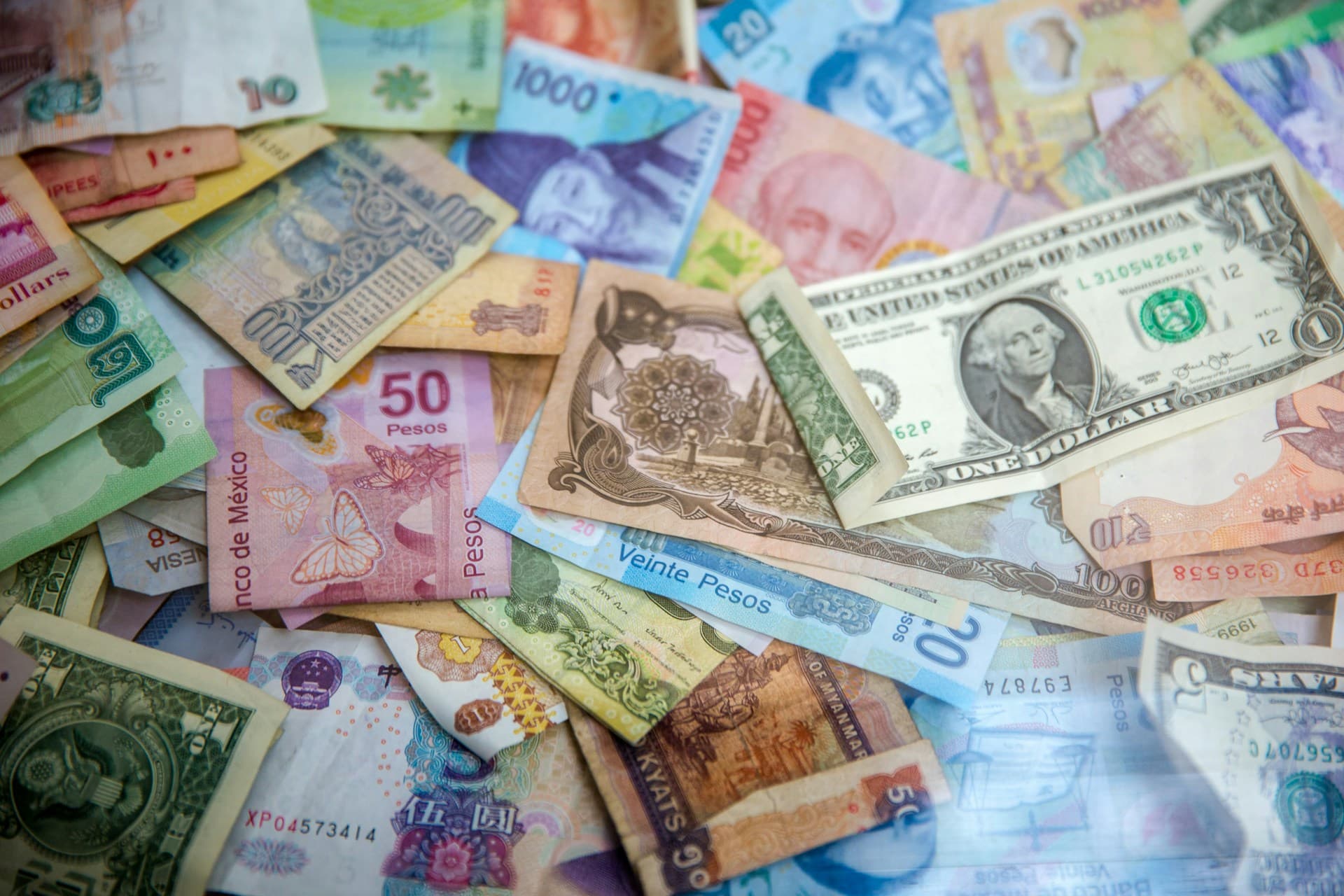 Colorful banknotes from different countries spread on a table